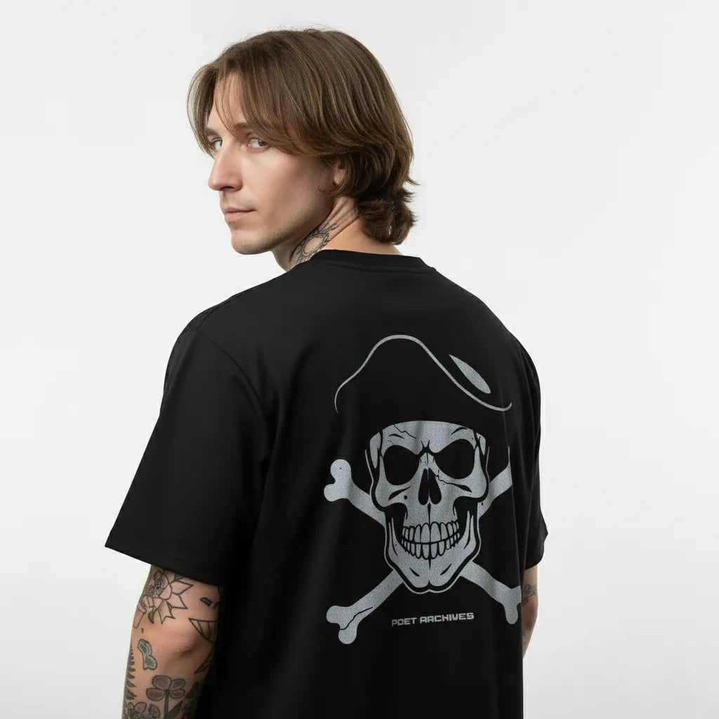 Person wearing a black t-shirt with a skull and crossbones design on the back, against a white background.