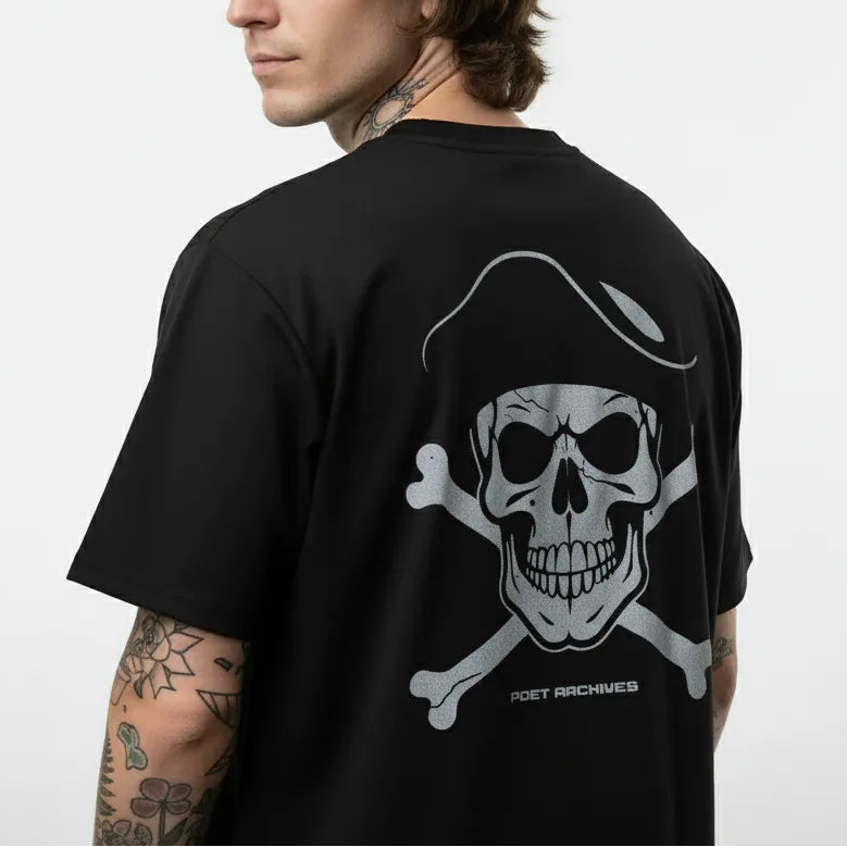 Person wearing a black t-shirt with a skull and crossbones design on the back, against a white background.