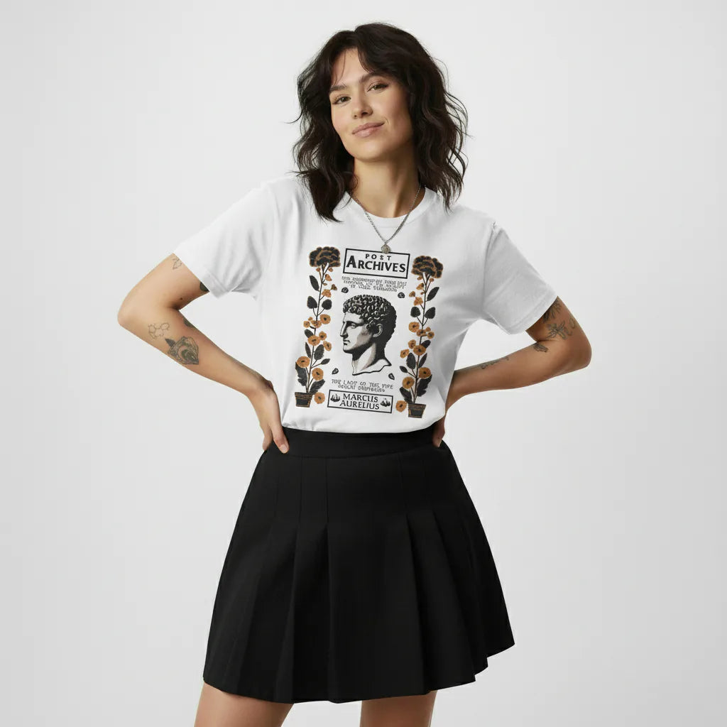 Woman wearing a white t-shirt with graphic design and a black skirt on a plain background