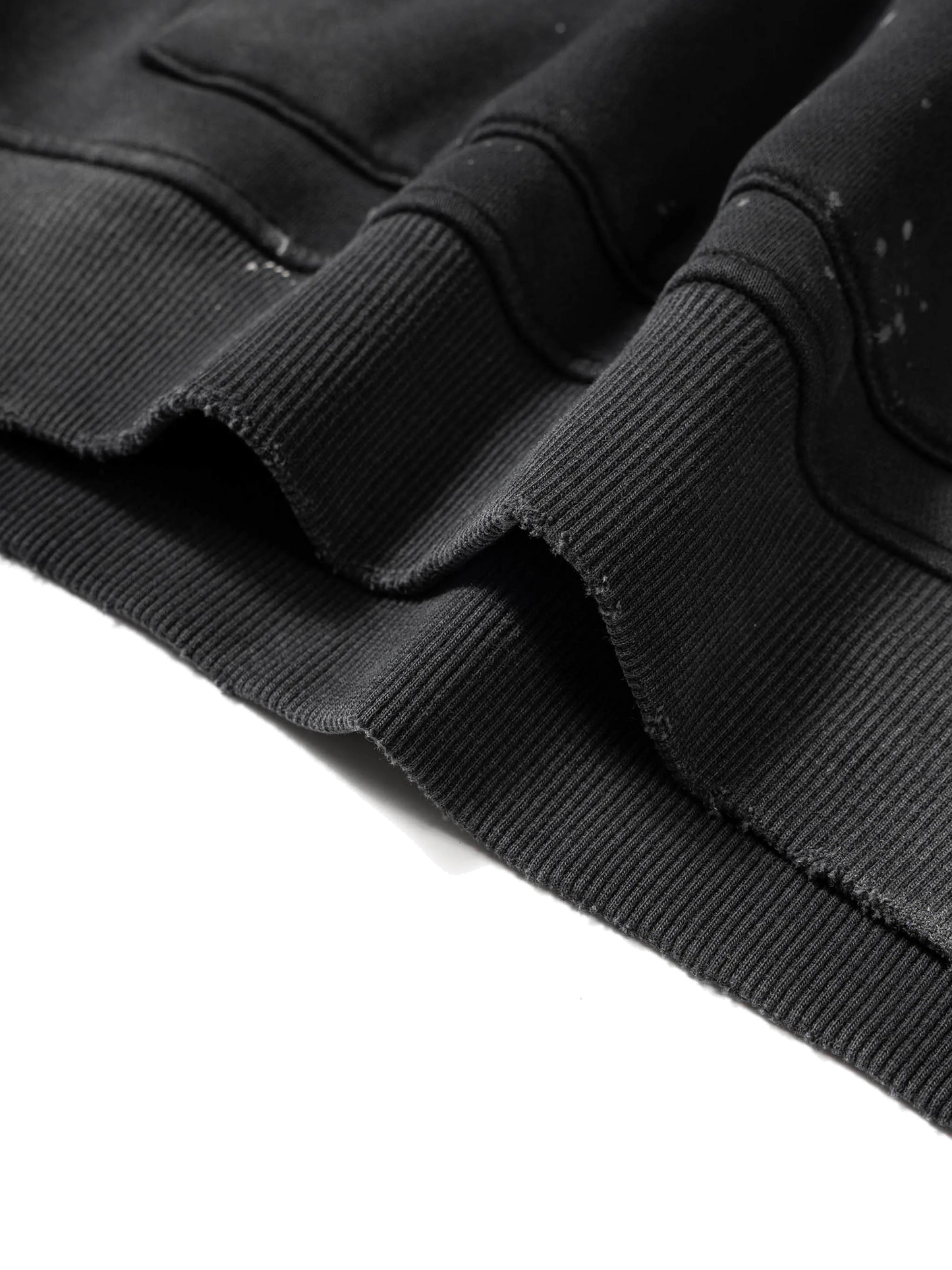 Close-up of a black jacket with frayed edges on a white background