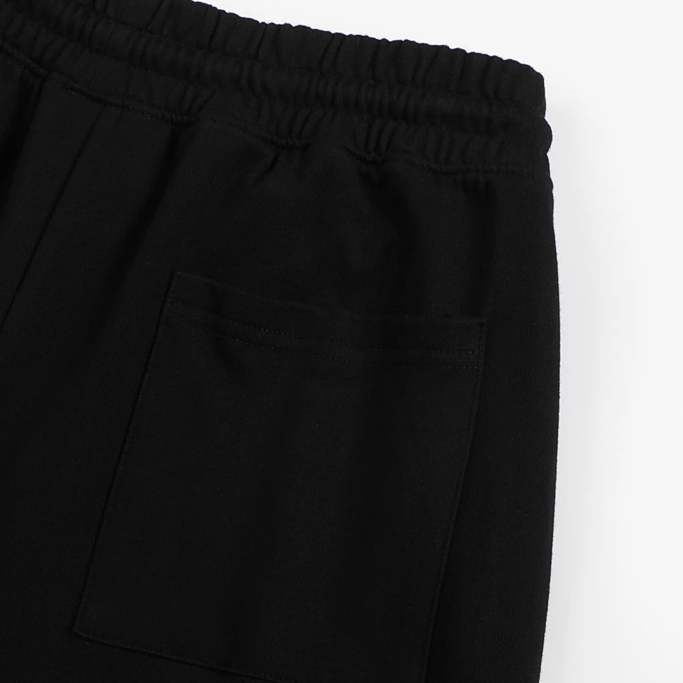 Close-up of black pants with a pocket on a white background