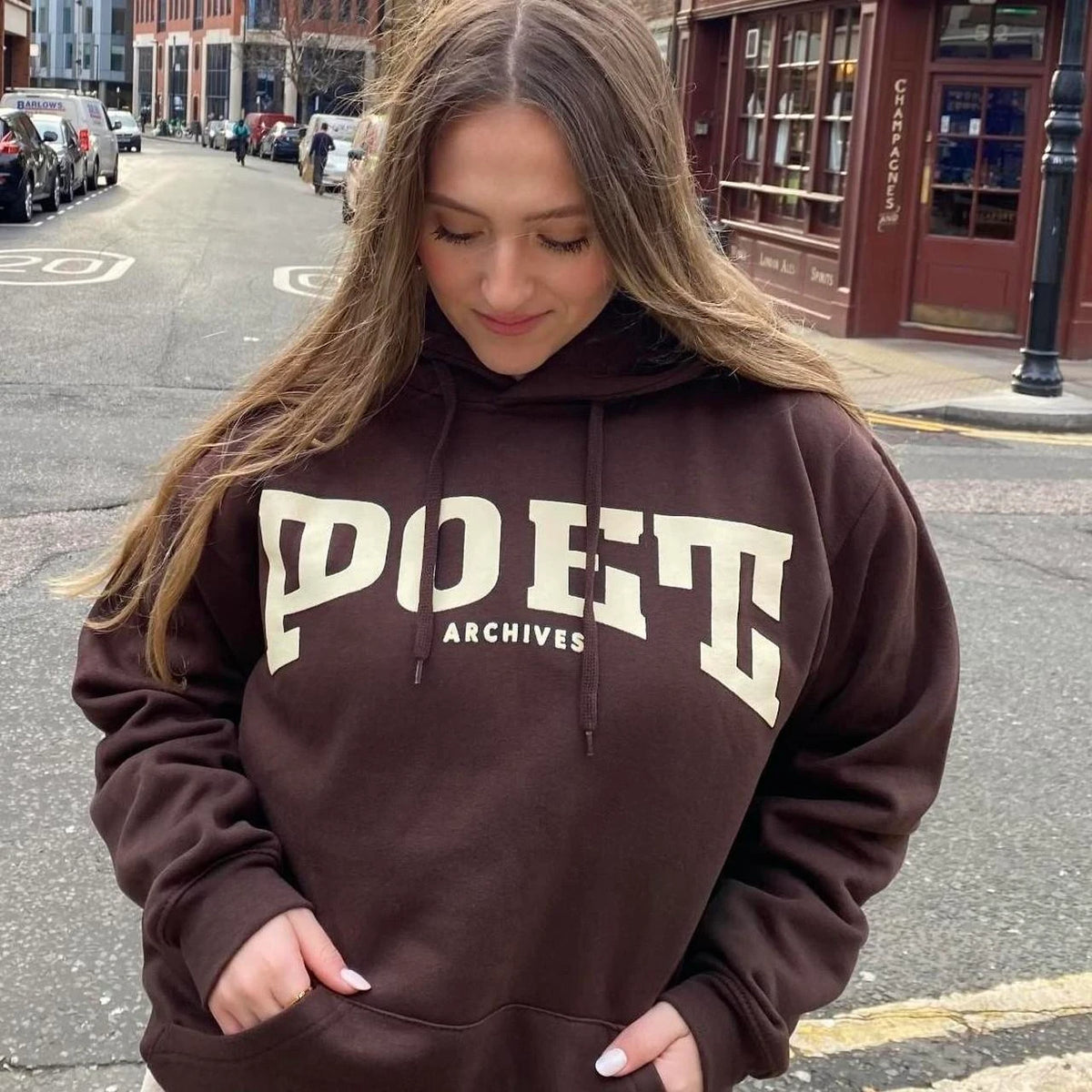 Front-facing view of the brown Freshman Hoodie with its bold spell-out logo graphic, from Poet Archives