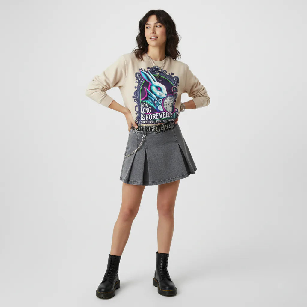 Woman wearing a graphic hoodie and denim skirt on a white background