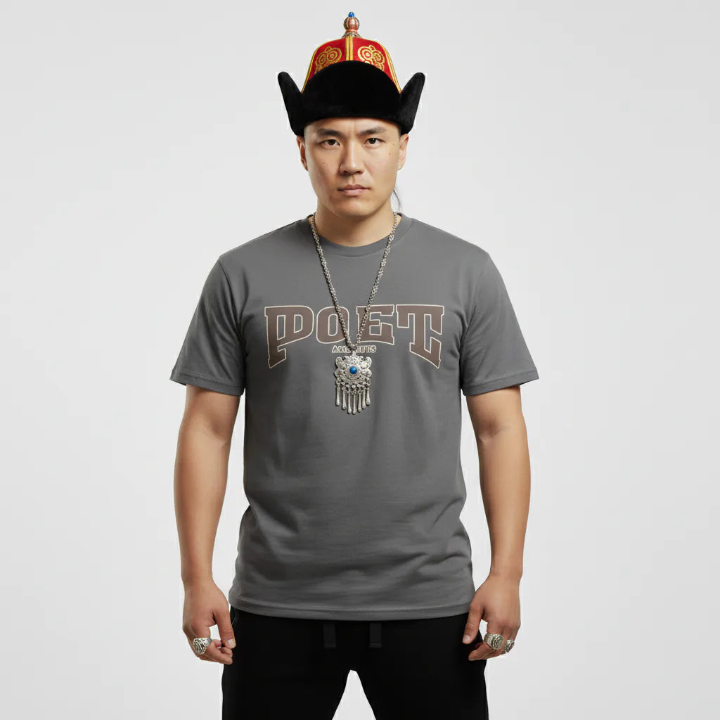 Person wearing a gray t-shirt with a logo and text, standing against a plain background