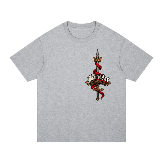 A heather gray short-sleeve t-shirt with a central graphic of a golden spear topped with a crown, wrapped in a red ribbon, and featuring the text 'Joan of Arc' in a decorative font.