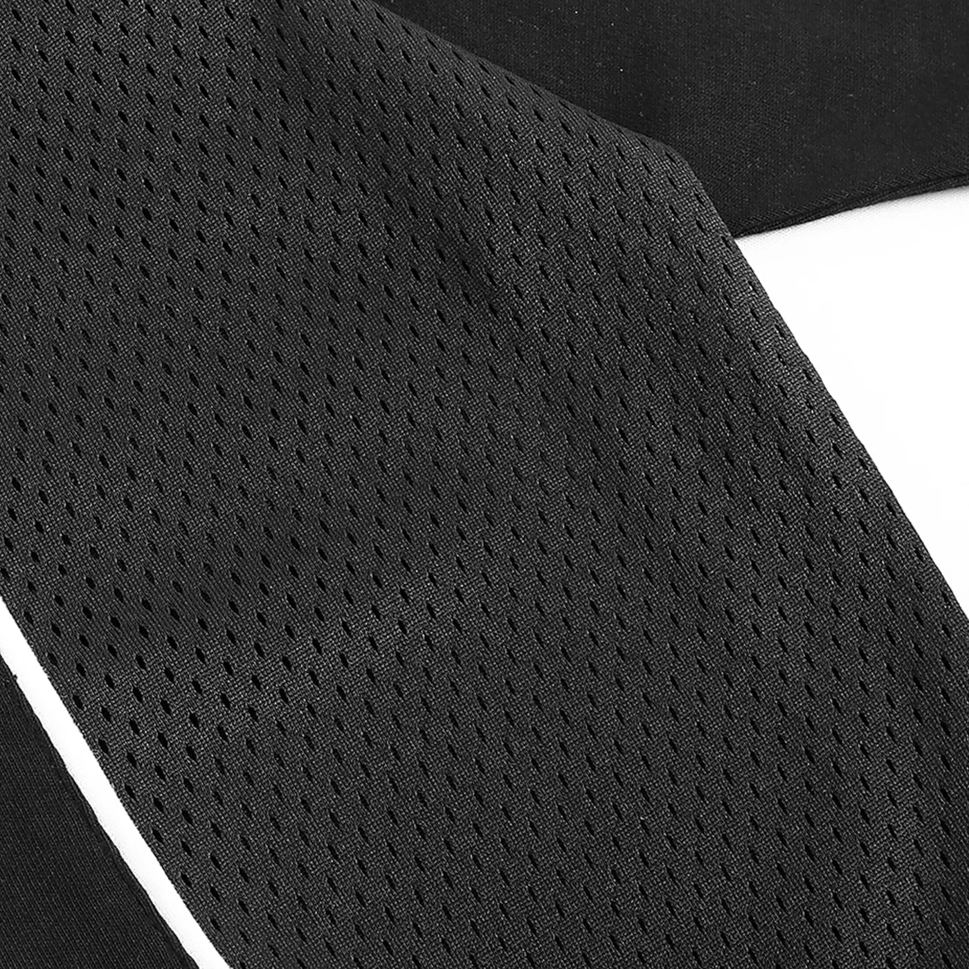 Close-up of black athletic shorts with mesh design on a white background