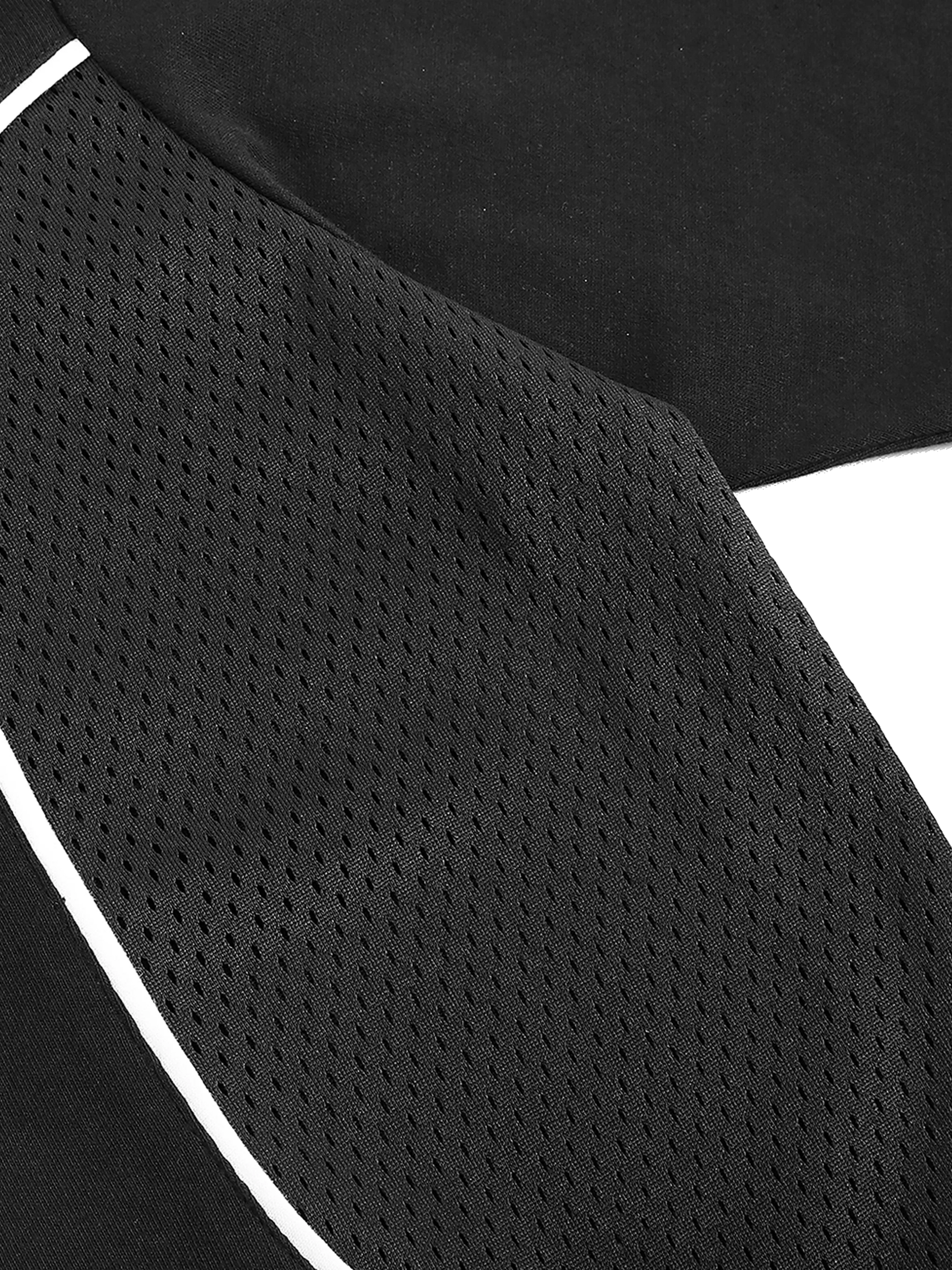 Close-up of a black athletic shirt with white mesh and trim