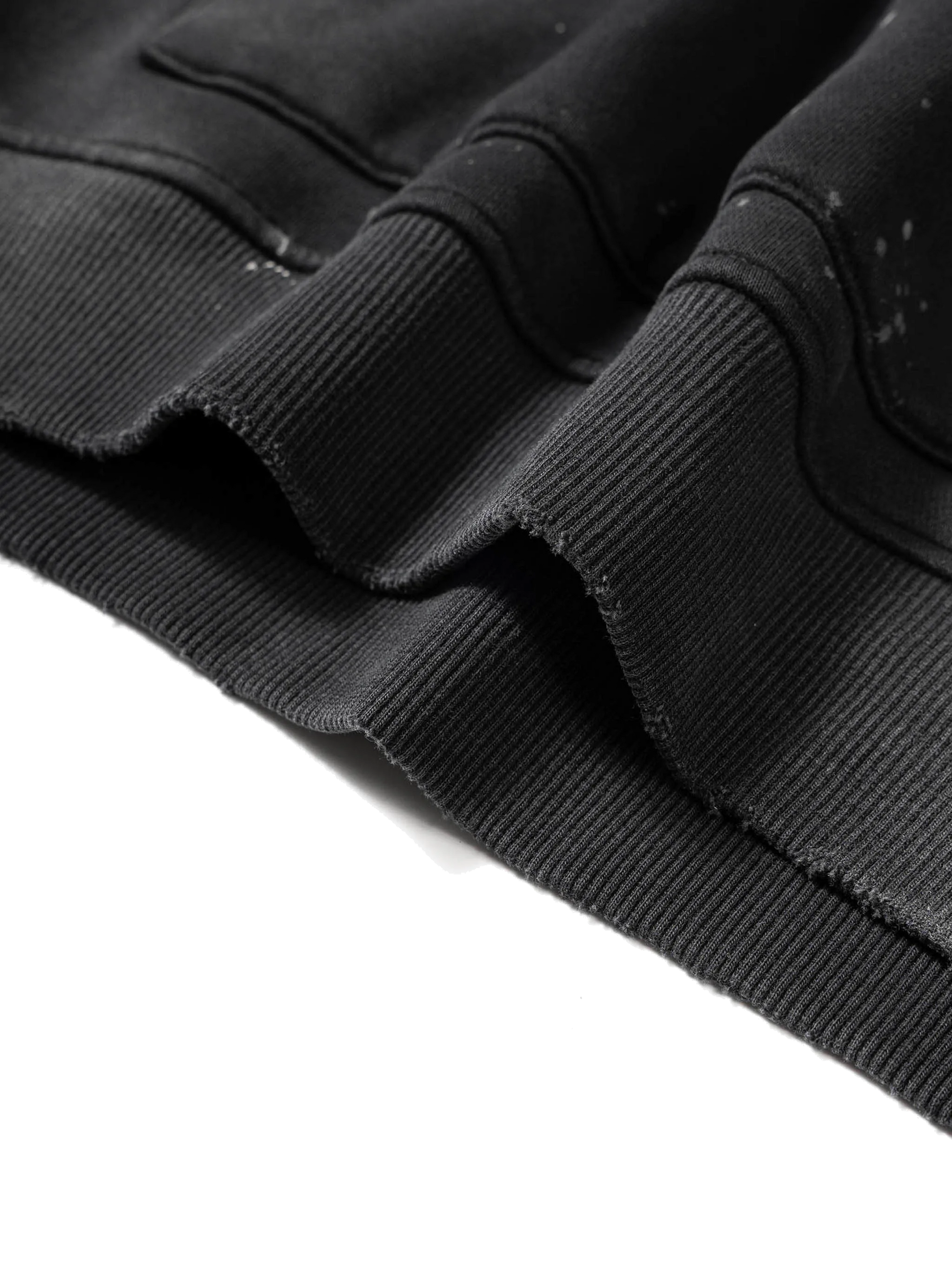 Close-up of a black jacket with frayed edges on a white background