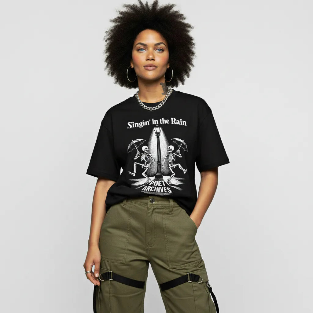 Person wearing a black t-shirt with graphic design and text, standing against a plain background