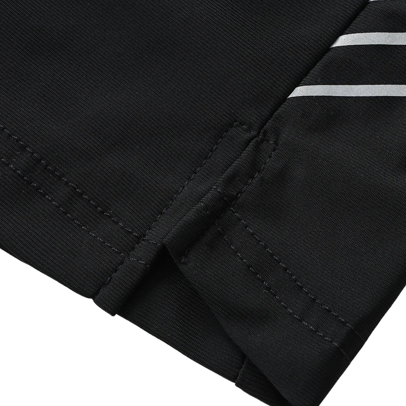 Close-up of black pants with a silver stripe on a white background