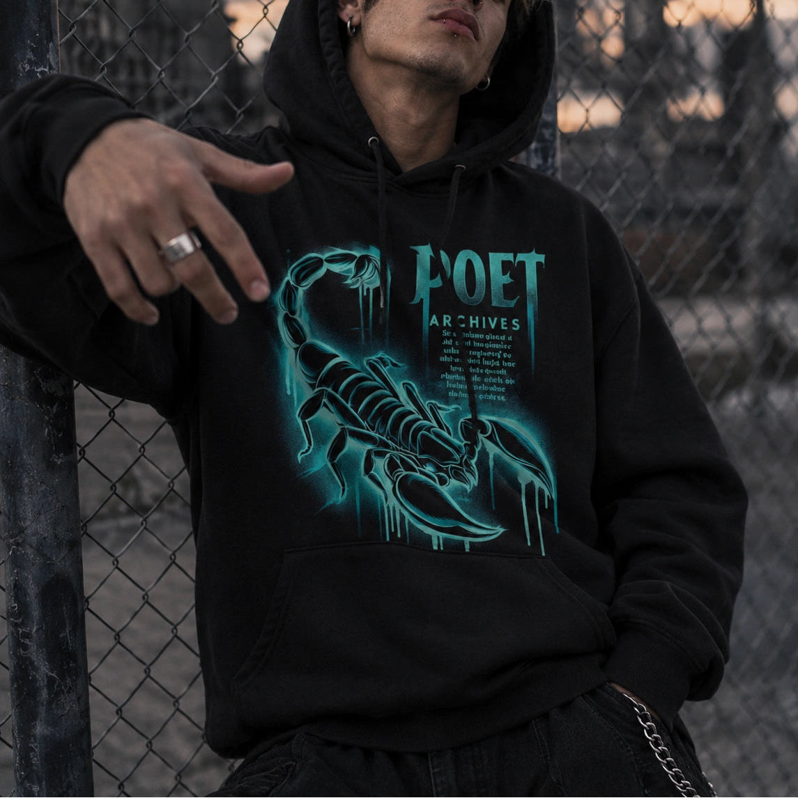 A man wearing a black hoodie with a glowing teal scorpion graphic and the text 'Poet Archives' leans against a chain-link fence outdoors at dusk.