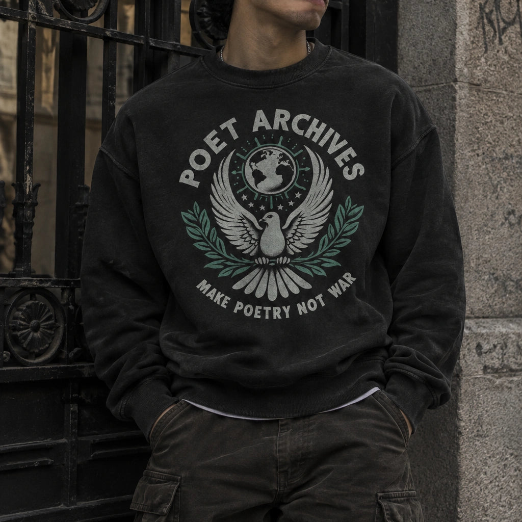 A man wearing a black beanie and a black crewneck sweatshirt with a white and green 'Poet Archives' bird graphic, leaning against a stone wall next to a black wrought-iron gate.