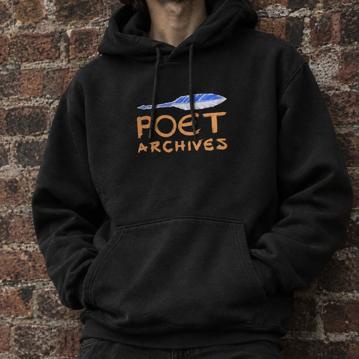 A person wearing a black pullover hoodie with a graphic print on the chest. The graphic features a blue and white fish illustration above the words 'POET ARCHIVES' in a warm orange-brown color.