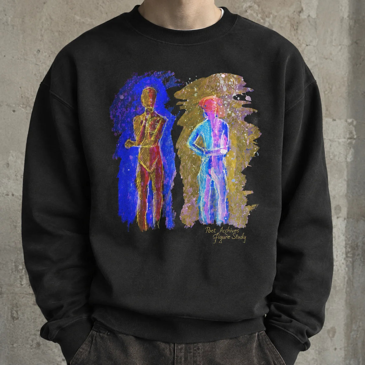 A person wearing a black crewneck sweatshirt with a colorful graphic print of two stylized human figures in blue, purple, and gold paint-splatter backgrounds, standing against a textured concrete wall.
