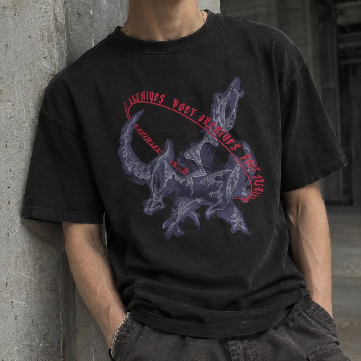A person wearing a faded black graphic T-shirt with a stylized purple dragon illustration and red curved text, leaning against a concrete wall in an urban setting.