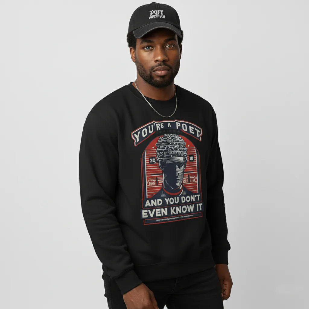 Man wearing a black sweatshirt with graphic design and text, standing against a plain background