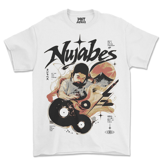 A white short-sleeve graphic T-shirt laid flat against a white background. The front features a large stylized black 'Nujabes' logo above an illustrated figure with a beard, vinyl records, stars, and abstract orange and black graphic elements.