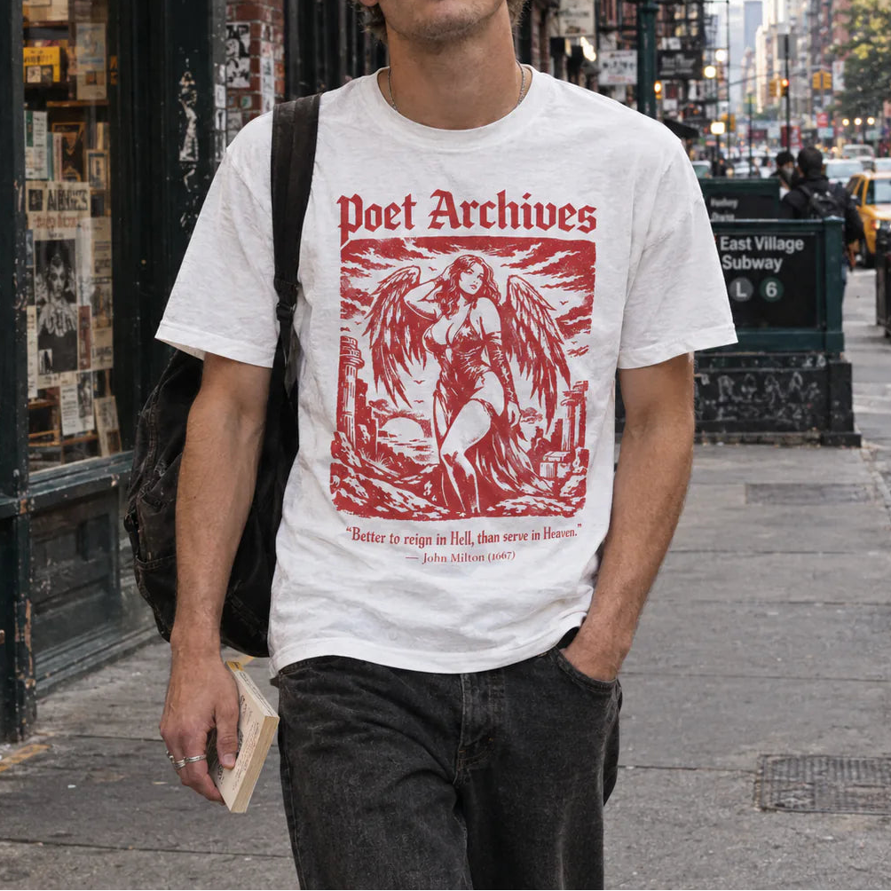 A young man walking on a city sidewalk wearing a white graphic t-shirt with a red 'Poet Archives' print, dark gray jeans, and a black shoulder bag. The background shows a busy urban street scene with a bookshop window on the left.