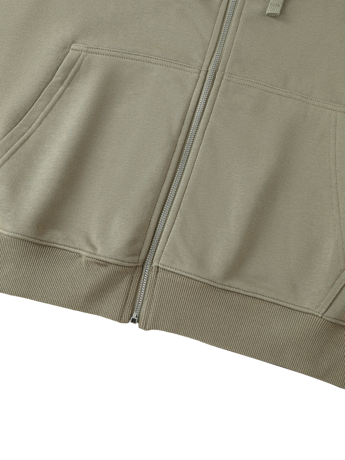 Close-up of a light khaki zip-up hoodie showing the front pockets, ribbed cuffs, and a silver zipper.