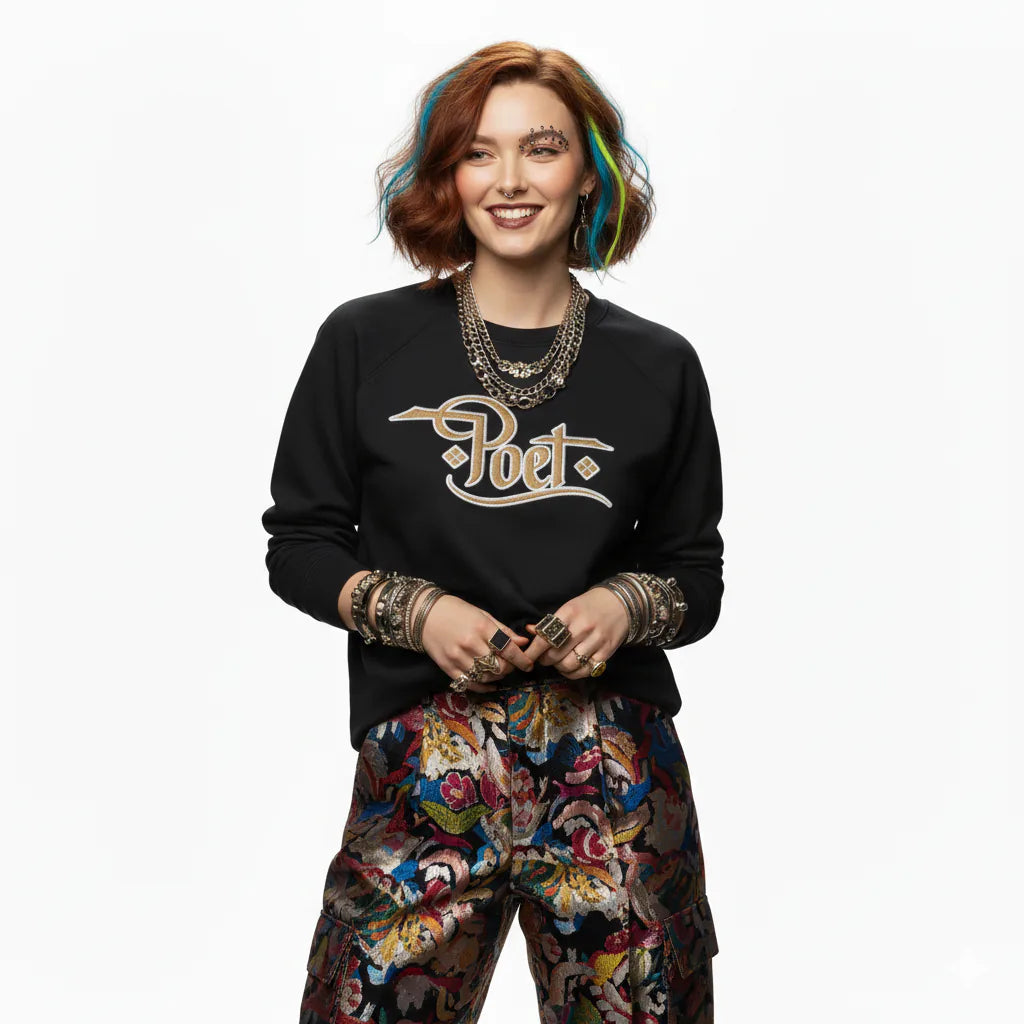 Person wearing a black sweatshirt with a logo and colorful pants on a white background